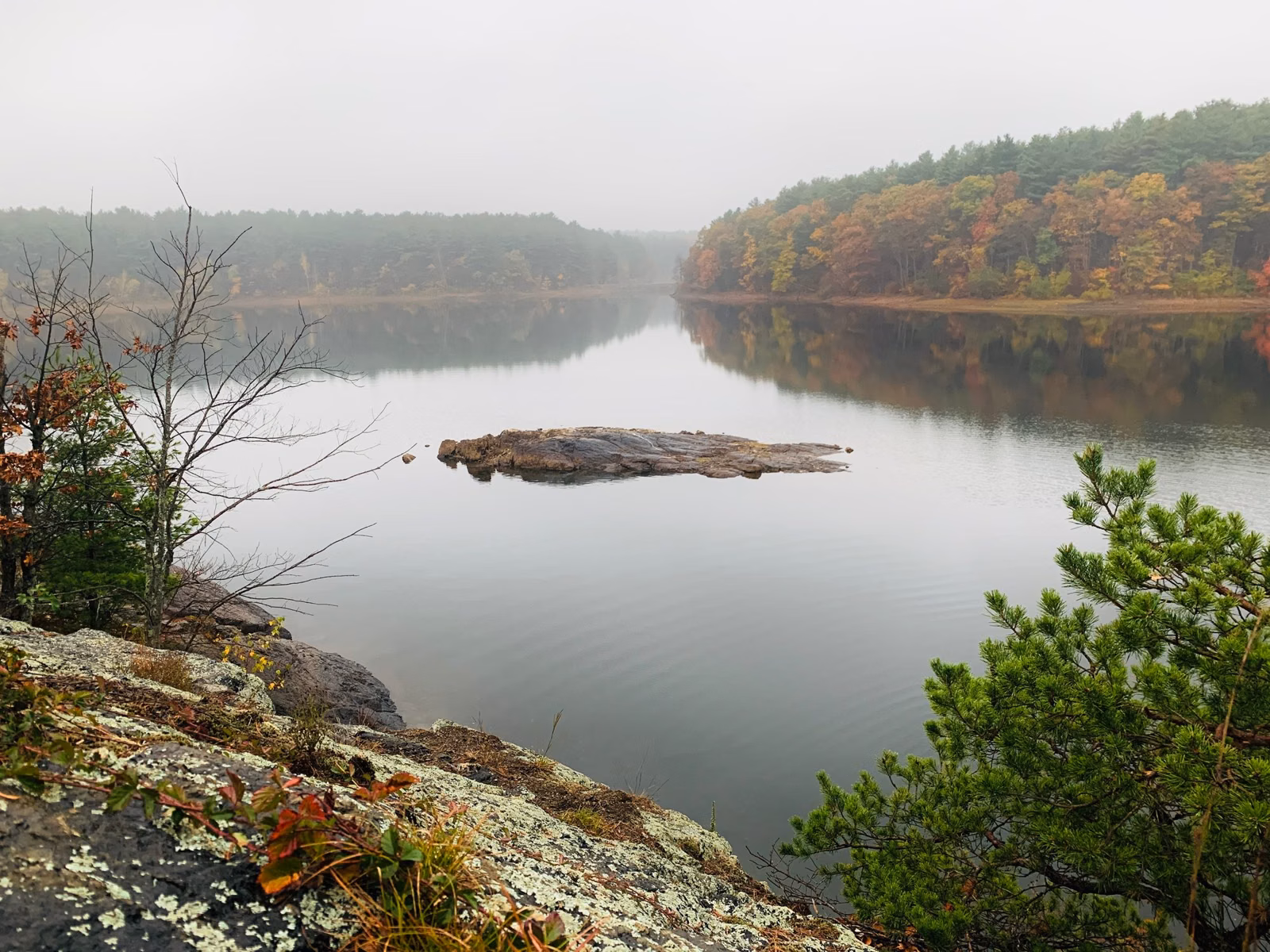 Fog over a reservoir with a small rock island, seen from a granite ledge, Middlesex Fells, Stoneham