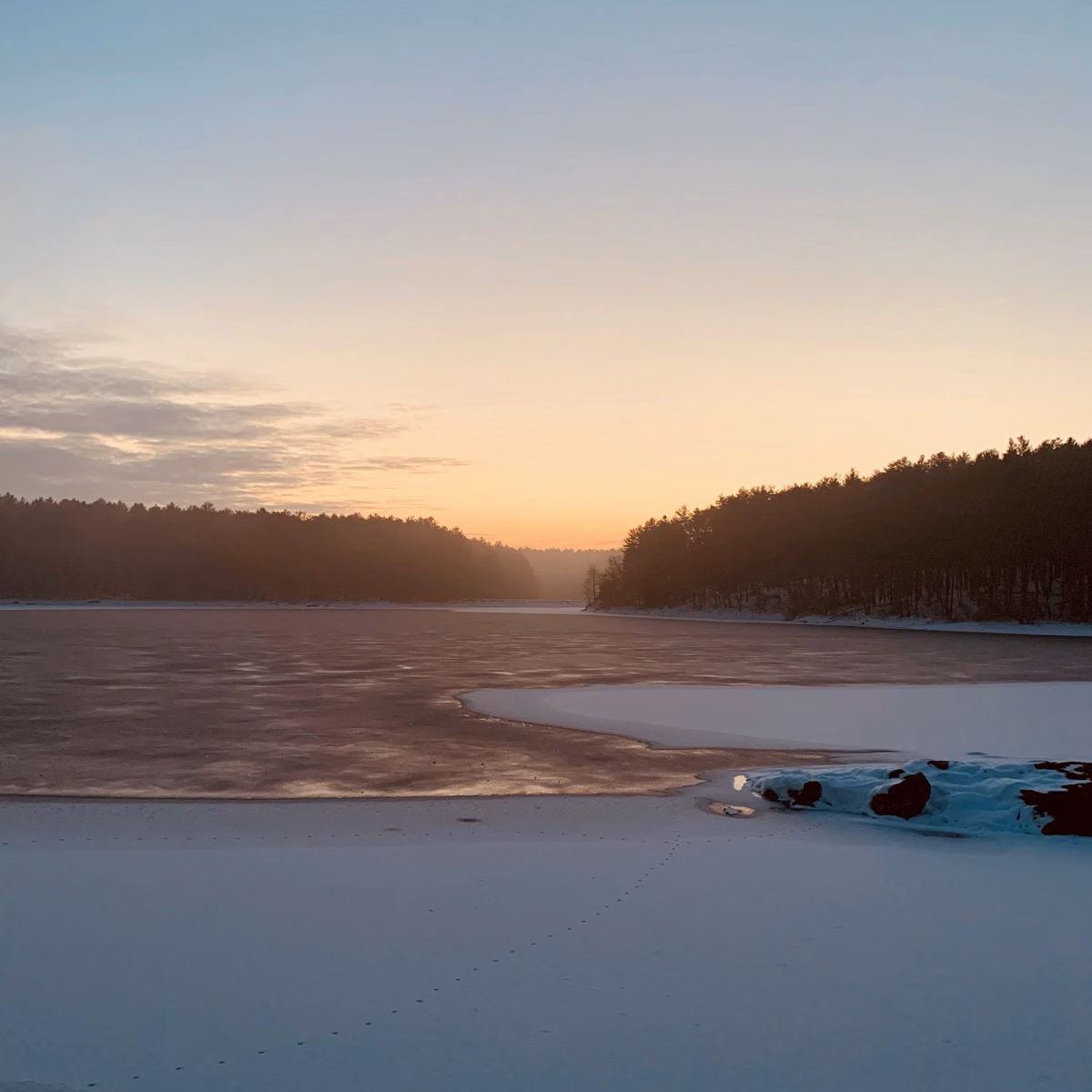 Frozen reservoir and snowy shore at winter sunset, Middlesex Fells